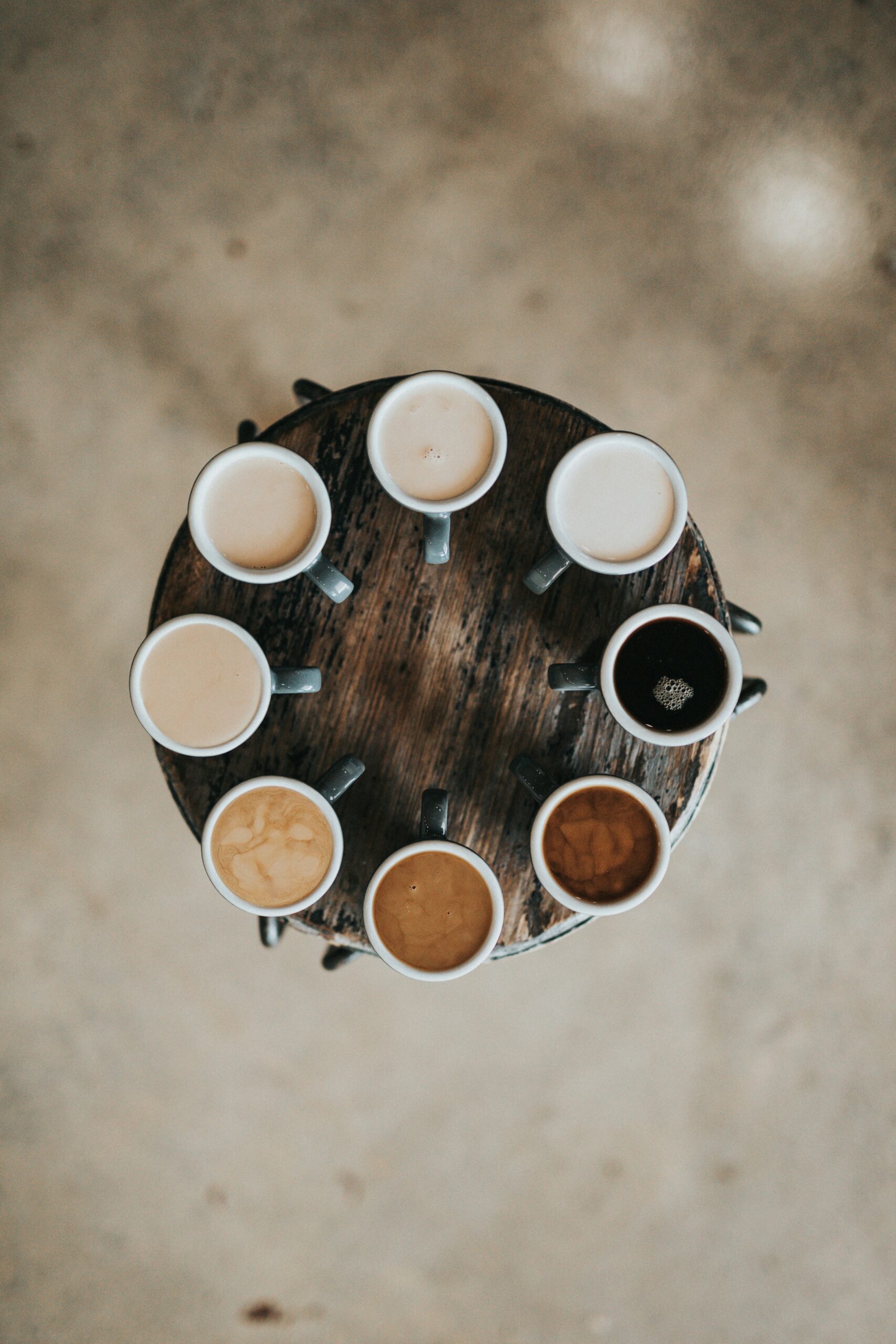 flat-lay-photography-of-eight-coffee-latte-in-mugs-on-round-table-scaled-1 A Cultura e o Consumo de Café nos Países Orientais